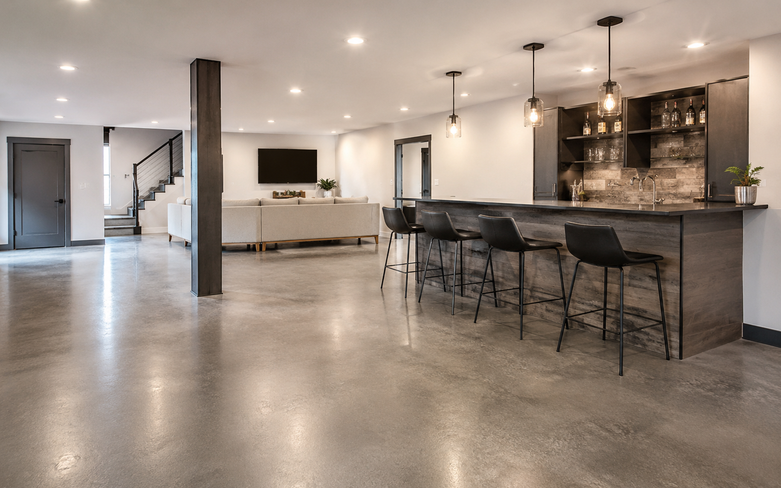 Modern residential basement or open-concept living space with polished concrete flooring